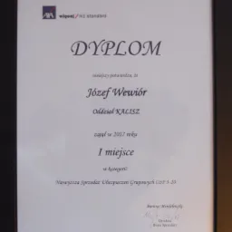 Oprawiony dyplom dla Józefa Wewióra z Oddziału Kalisz za zajęcie I miejsca w 2017 roku w kategorii najwyższej sprzedaży ubezpieczeń grupowych, podpisany przez dyrektora biura sprzedaży Bartosza...