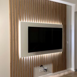 Zabudowa telewizora z podświetleniem taśmą LED i elementami dekoracyjnymi w postaci lameli ściennych 