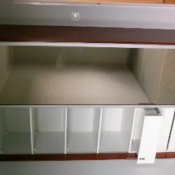 Wnętrze szafy wnękowej z p&oacute;łkami i szufladami, widok z g&oacute;ry, realizacja w Poznaniu.