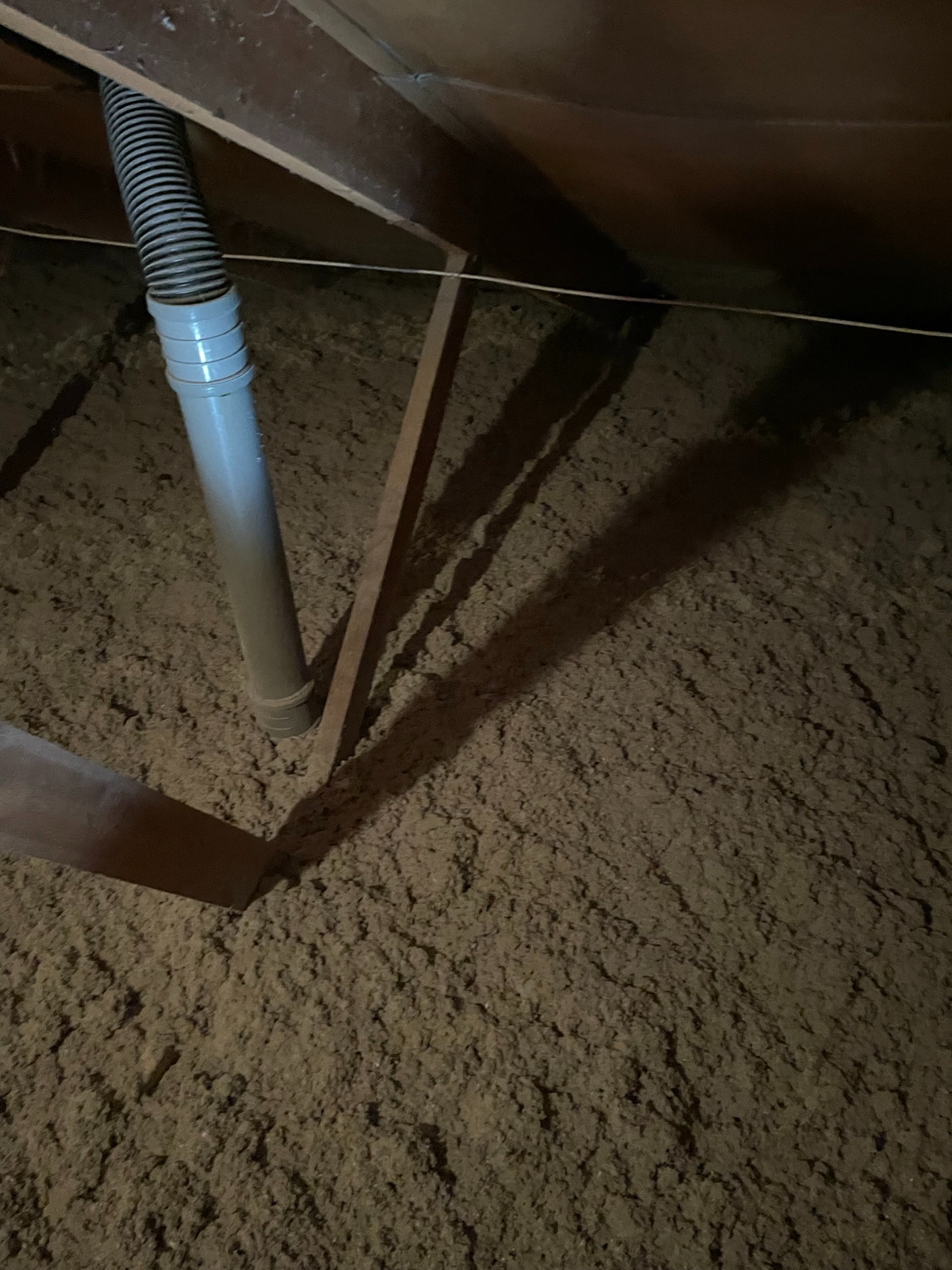 Poddasze ocieplone brązową pianką PUR z widocznym szarym przewodem wentylacyjnym i elementami konstrukcji drewnianej