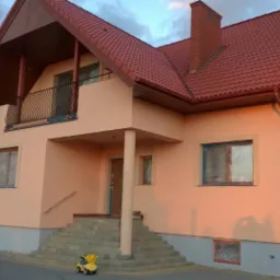 Dom po malowaniu elewacji w Załuskach, z widocznymi zabezpieczonymi oknami i zabawką dziecka na schodach.