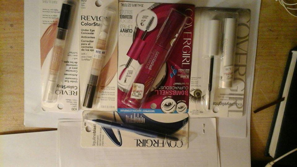 Rozłożone na stole produkty do makijażu marki Covergirl i Revlon: korektory, tusze do rzęs i eyeliner w oryginalnych opakowaniach.