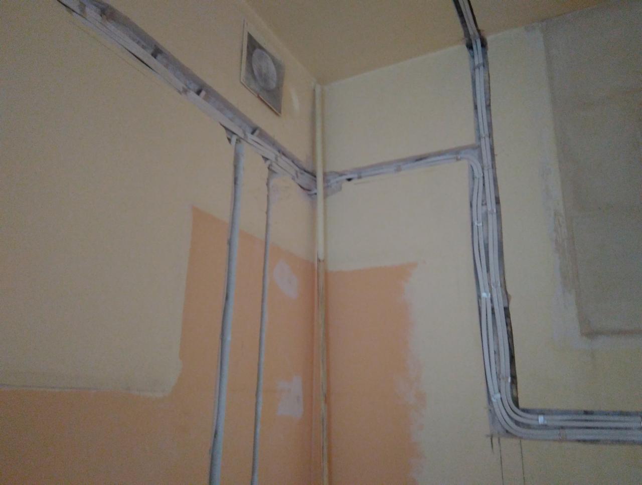 Kable elektryczne prowadzone wzdłuż ścian wewnątrz budynku, zabezpieczone listwami. Ściany w trakcie malowania, widoczne fragmenty w innym kolorze.