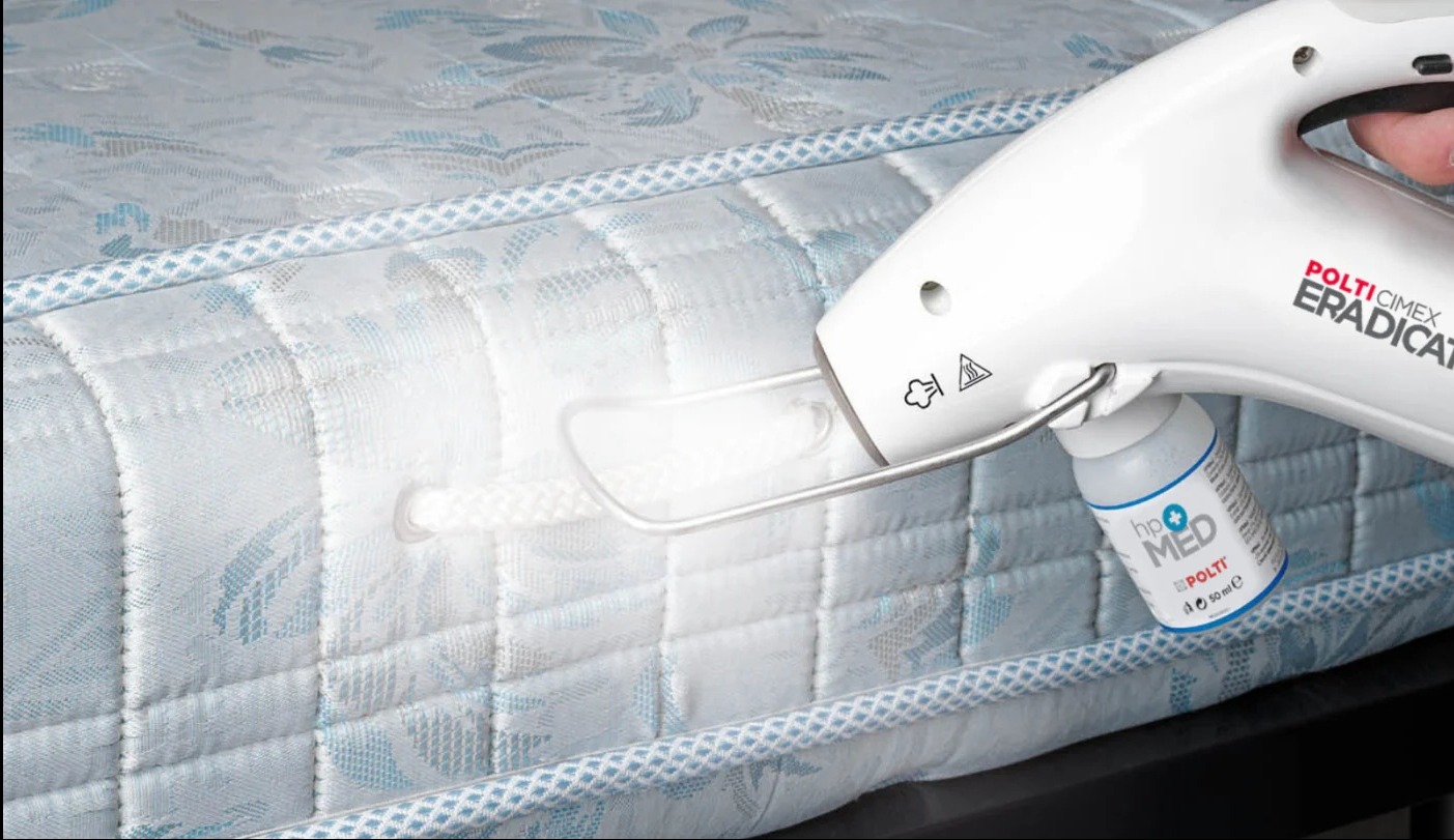 Czyszczenie parowe materaca za pomocą urządzenia Polti Cimex Eradicator z dodatkowym płynem hp MED, skupiając się na usuwaniu potencjalnych alergenów i drobnoustrojów.