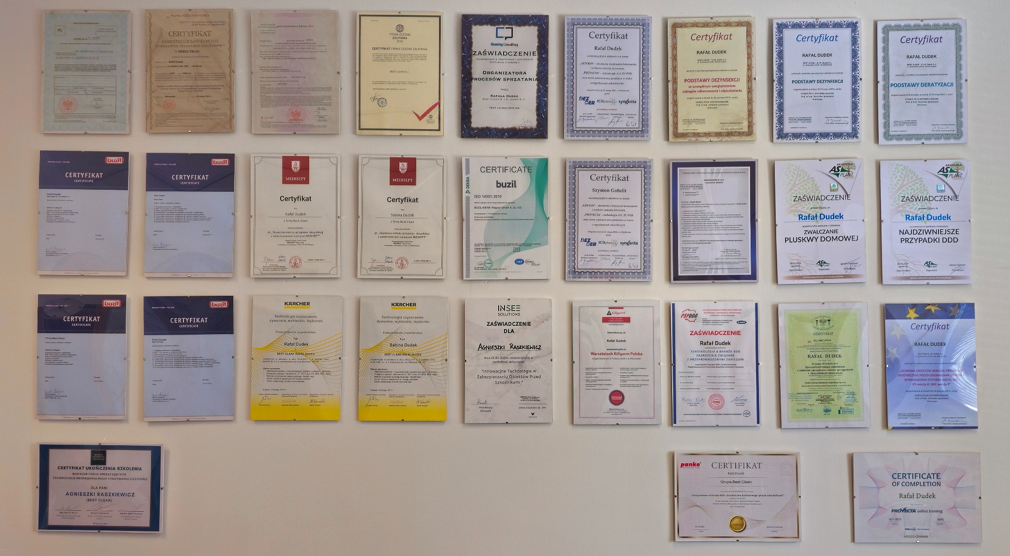 Ściana z licznymi certyfikatami i zaświadczeniami, różnej wielkości i oprawione w ramki, w większości z imieniem i nazwiskiem Rafał Dudek, niektóre dotyczą zwalczania szkodników, dezynfekcji...