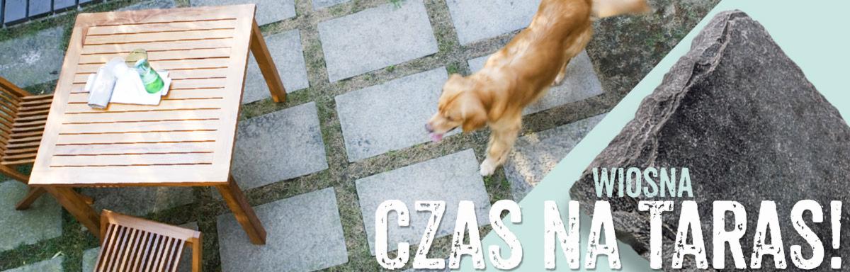 Ułożona nawierzchnia z kwadratowych płyt, drewniany stół z krzesłami oraz pies rasy golden retriever na tle napisu 'Wiosna, czas na taras!'
