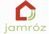 Logo firmy Jamróz przedstawiające czerwony symbol domu z zielonymi elementami, umieszczone nad zielonym napisem 'jamróz'.
