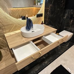 MYSTEK SPÓŁKA Z OGRANICZONĄ ODPOWIEDZIALNOŚCIĄ - Nowoczesna szafka łazienkowa z owalną umywalką i otwartymi szufladami. Drewno o jasnym odcieniu, dekoracyjne uchwyty. W tle lustro z podświetleniem i marmurowe wykończenie.