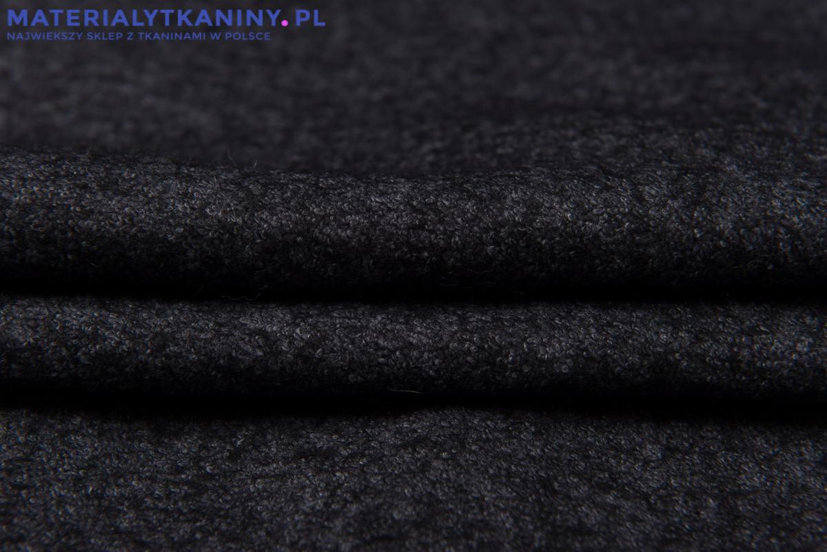 Ciemnoszara, drapana tkanina wełniana z widoczną fakturą i delikatnym połyskiem, ułożona w fałdy.