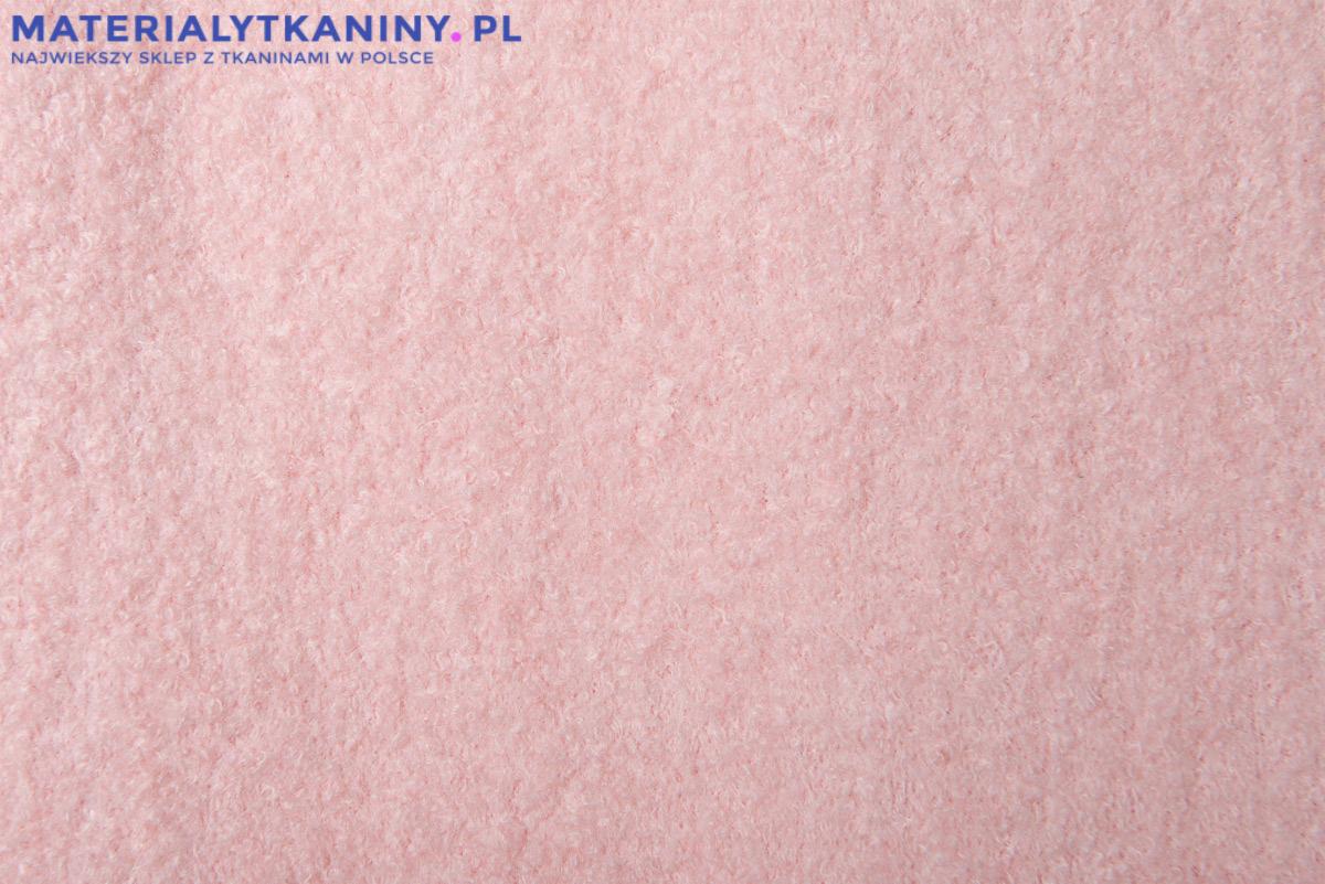 Delikatna, puszysta tkanina w odcieniu pudrowego różu, z widoczną fakturą włókien, prezentowana na jednolitym tle z subtelnym logo sklepu internetowego w górnym rogu.