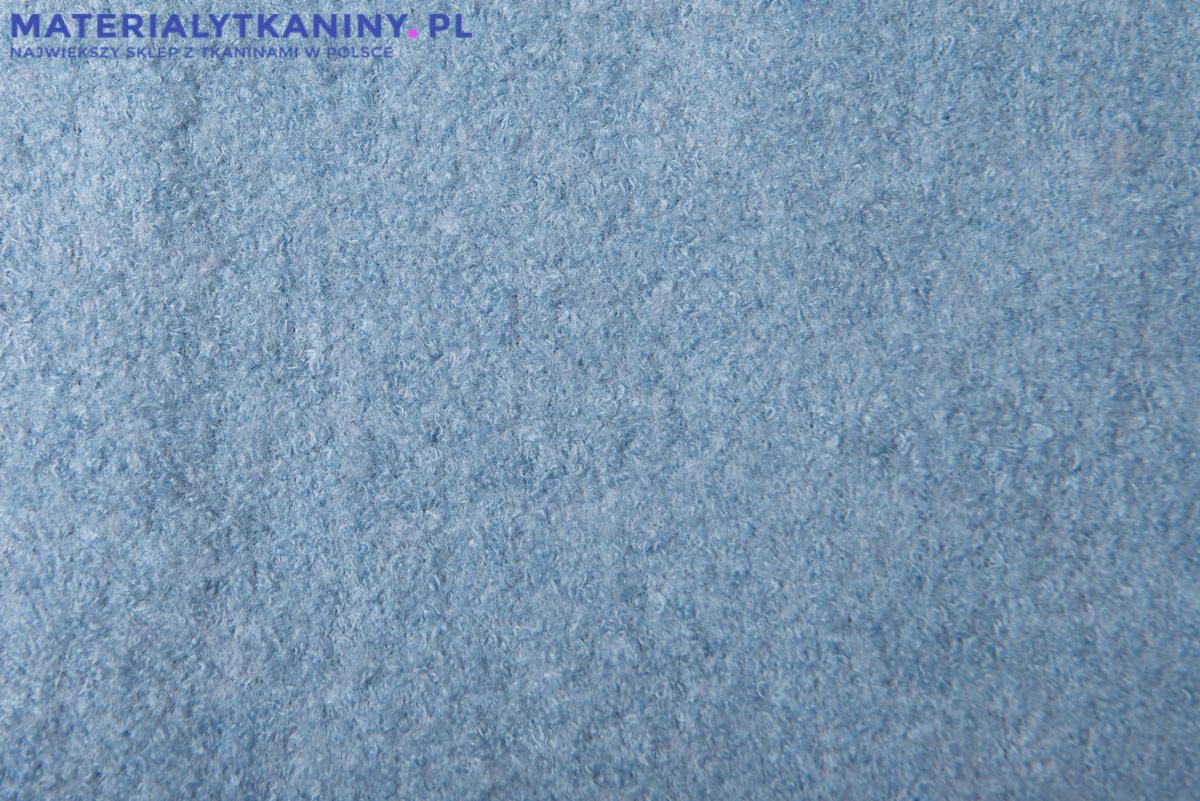 Błękitna, puszysta tkanina wełniana o nieregularnej fakturze, z widocznym znakiem wodnym firmy w górnej części
