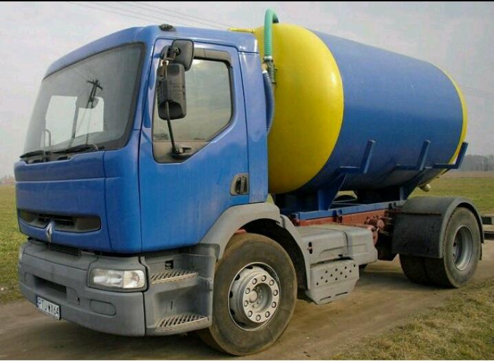 Ciężarówka Renault z niebiesko-żółtym zbiornikiem na podwoziu, zaparkowana na polnej drodze.