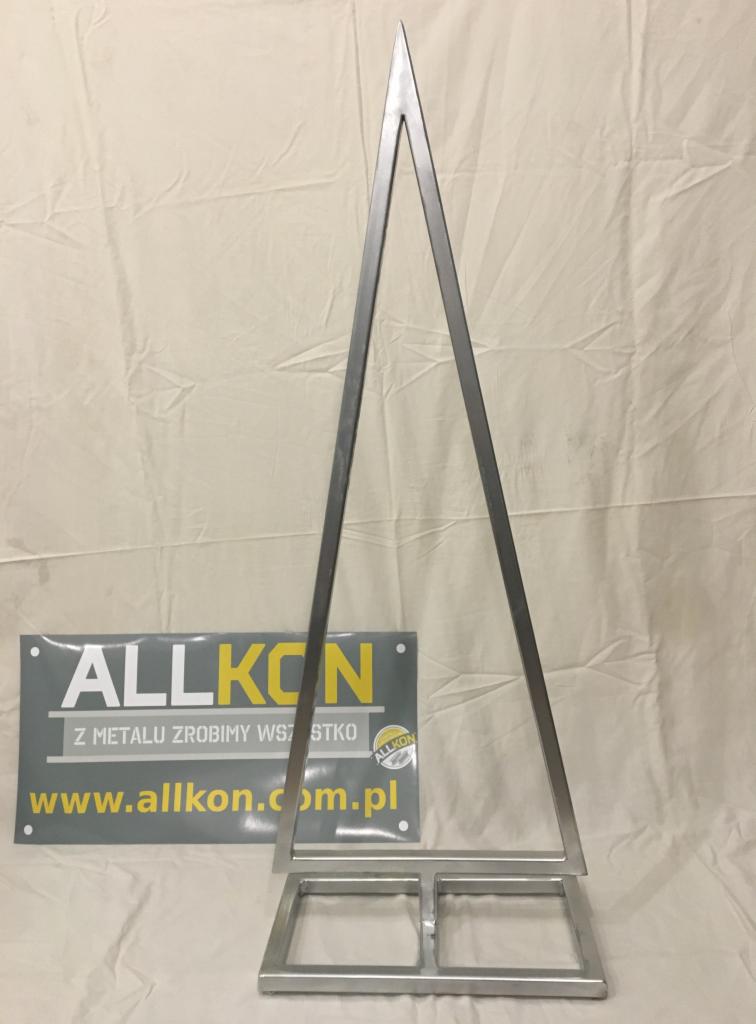 Metalowa konstrukcja w kształcie trójkąta z podstawą, prezentowana na tle białego materiału obok baneru reklamowego firmy ALLKON.