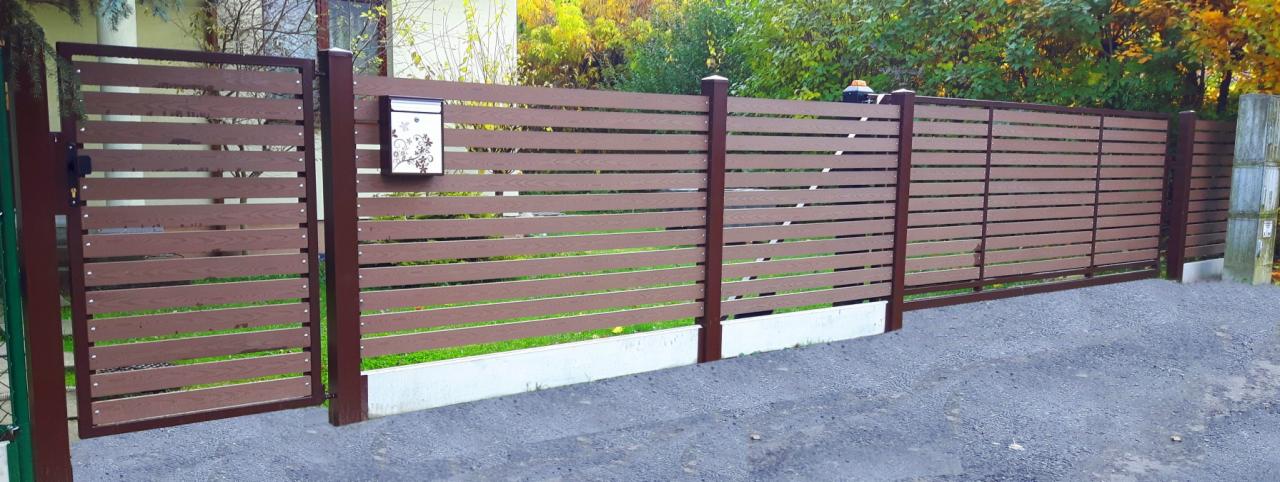 Nowoczesne ogrodzenie posesji z poziomych paneli w kolorze brązowym, z furtką i skrzynką pocztową z motywem kwiatowym.