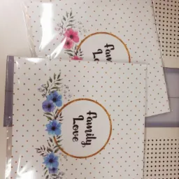 Dwa identyczne, zafoliowane kalendarze z motywem kwiatowym i napisem 'Family Love' na białym tle w złote kropki, ułożone jeden na drugim.