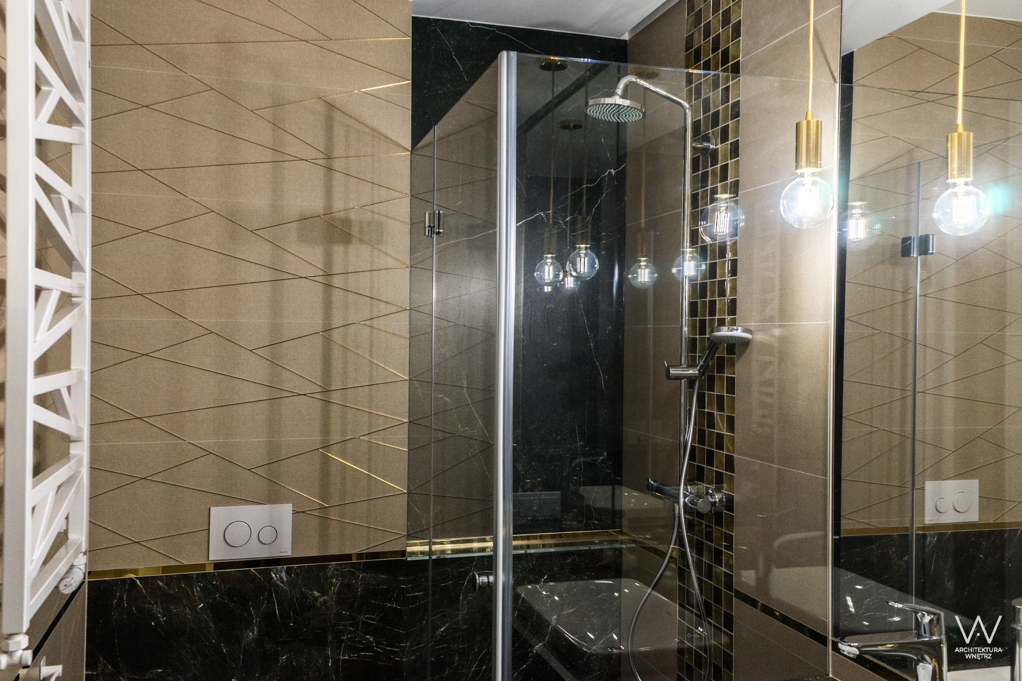 Nowoczesna łazienka z kabiną prysznicową typu walk-in, marmurowymi i geometrycznymi płytkami oraz dekoracyjnymi żarówkami na złotych przewodach.