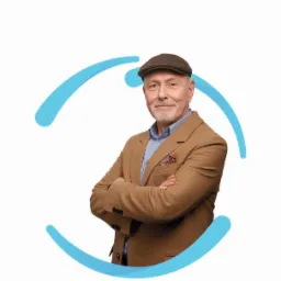 Uśmiechnięty, starszy mężczyzna w tweedowej marynarce i kaszkiecie, z rękami założonymi na piersi, na białym tle z elementami graficznymi w kolorze błękitnym.