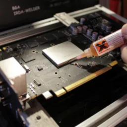 Aplikacja pasty lutowniczej na chip graficzny na płycie głównej za pomocą dozownika w profesjonalnym stanowisku lutowniczym BGA IRDA-WELDER.