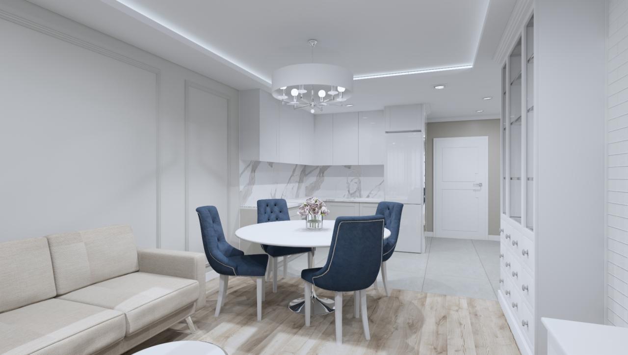 Jasne wnętrze z sofą w odcieniach beżu, okrągłym białym stołem otoczonym czterema granatowymi krzesłami z pikowaniem, oraz białą zabudową kuchenną z marmurowym backsplashiem.