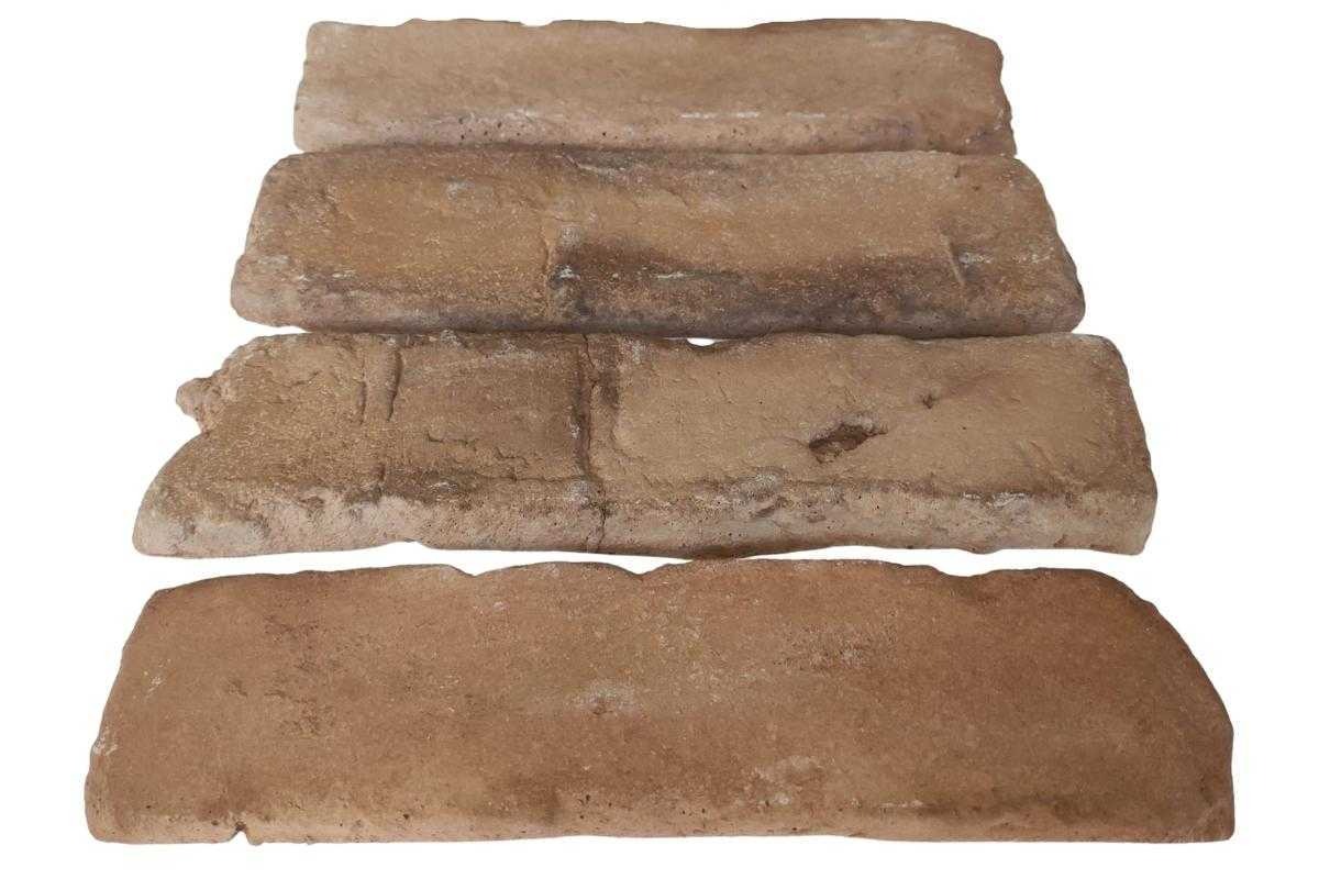 Cztery brązowe płytki ceglane ułożone jedna na drugiej, widoczne nieregularne krawędzie i porowata faktura.