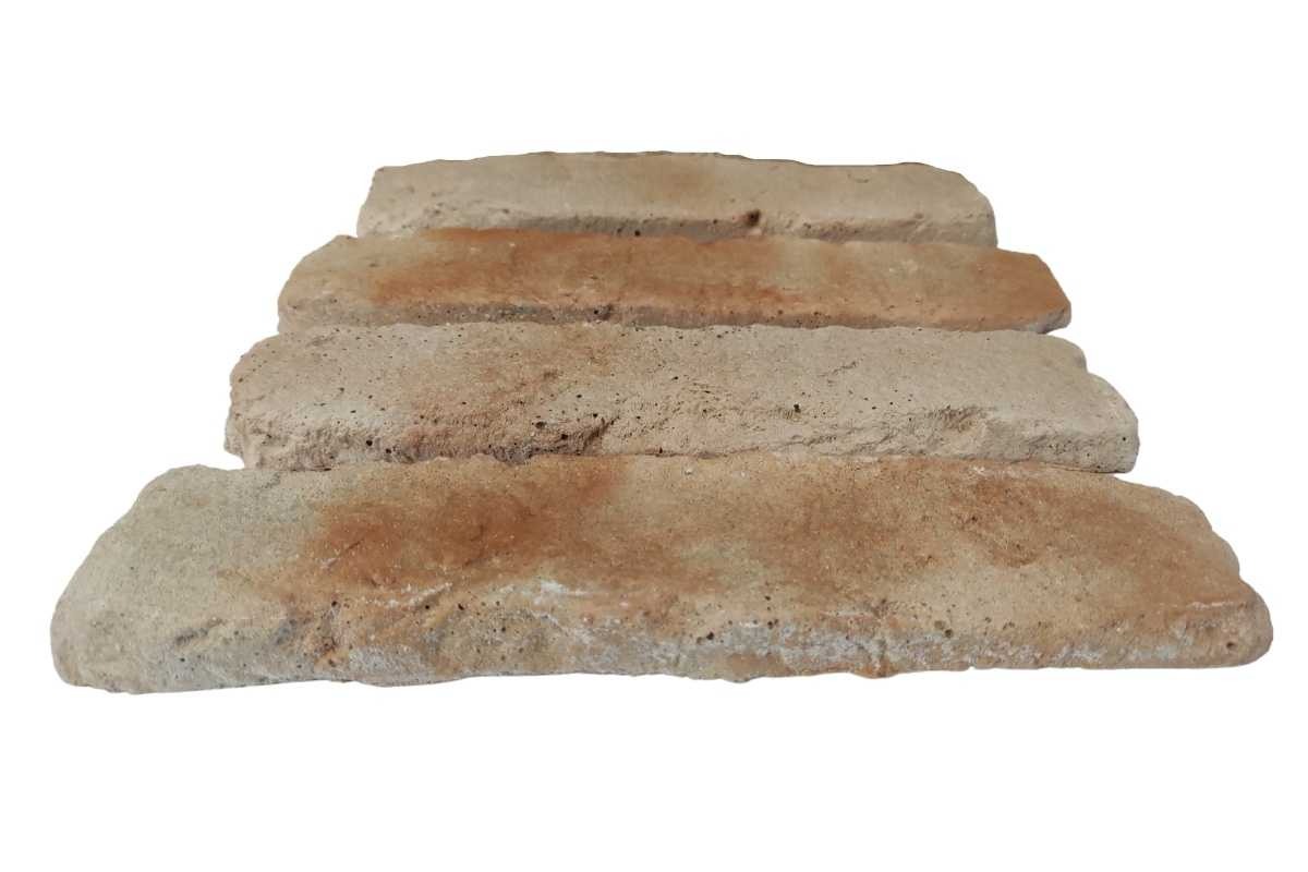 Cztery beżowo-pomarańczowe płytki ceglane ułożone warstwowo na białym tle, prezentujące porowatą strukturę i nieregularne krawędzie.