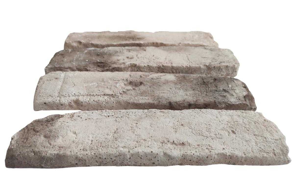 Cztery ułożone warstwowo płytki ceglane w odcieniach beżu i szarości, ukazujące porowatą strukturę i nieregularne krawędzie.