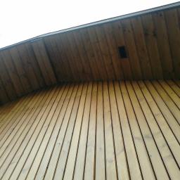 Korsuper - Drewniana boazeria elewacyjna z widoczną kratką wentylacyjną pod okapem, wykonana z jasnego drewna ułożonego pionowo.