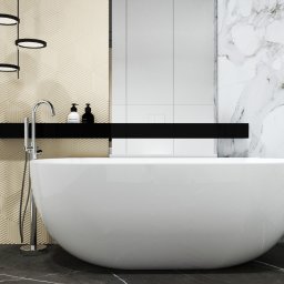 Pracownia Projektowa Blockdesign Ewa Skowrońska - Nowoczesna łazienka z wolnostojącą wanną na tle marmurowej ściany i geometrycznej faktury. Minimalistyczne oświetlenie i czarne akcenty dodają elegancji.