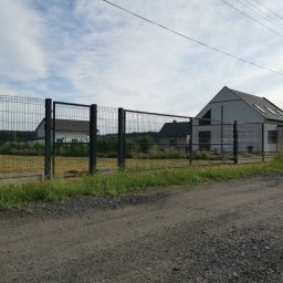 LIVBET-ECO - Ogrodzenia Systemowe - Szare ogrodzenie panelowe z furtką, zabezpieczające posesję z nowoczesnym domem w tle, Kamień Pomorski.