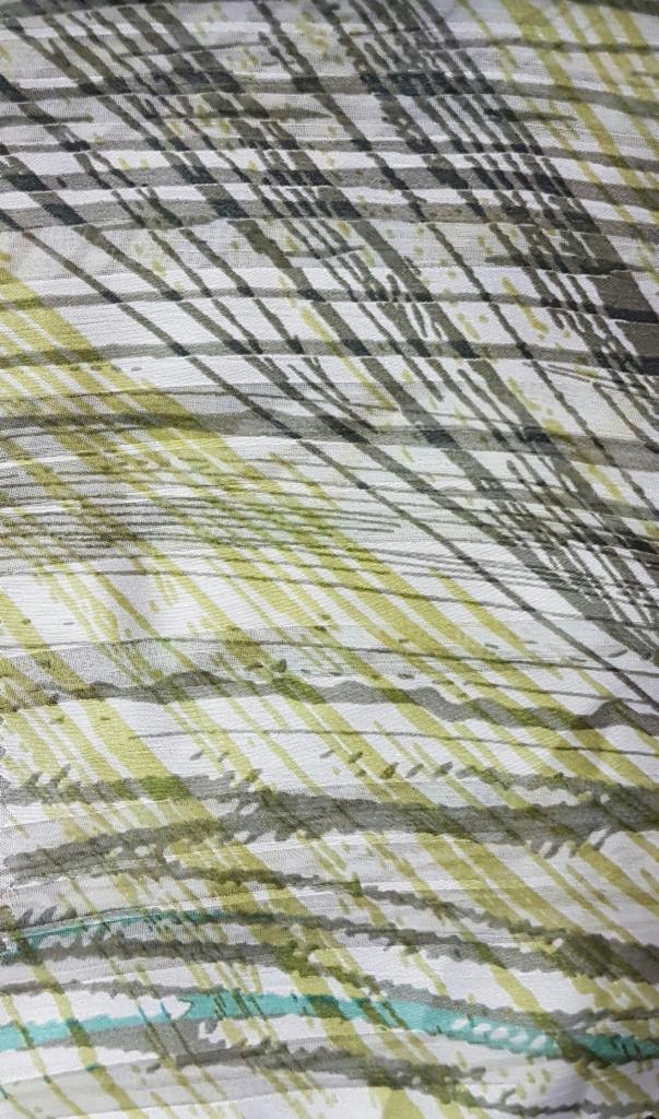 Detale tkaniny z abstrakcyjnym wzorem w odcieniach zieleni, szarości i bieli, przypominającym pociągnięcia pędzla.