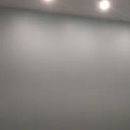 Świeżo pomalowana ściana w odcieniach szarości z równomiernie rozmieszczonymi punktowymi lampami sufitowymi, widoczne delikatne niedoskonałości powierzchni.