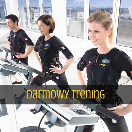 Trzy osoby w strojach do elektrostymulacji mięśni ćwiczą na bieżniach w jasnym pomieszczeniu z dużymi oknami i widokiem na miasto.