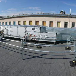 System wentylacji mechanicznej z rekuperacją zamontowany na dachu budynku, zabezpieczony barierkami ochronnymi.