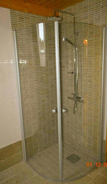 Kabina prysznicowa narożna z chromowaną armaturą i mozaiką w odcieniach beżu i brązu, widok na odpływ liniowy w podłodze.