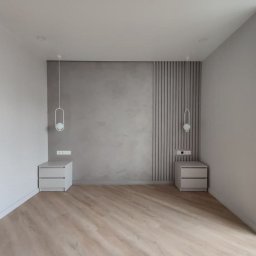 RP Work Sp. z o.o. - Minimalistyczna sypialnia z szarą ścianą, drewnianą podłogą, białymi szafkami nocnymi i wiszącymi lampami o owalnym kształcie.