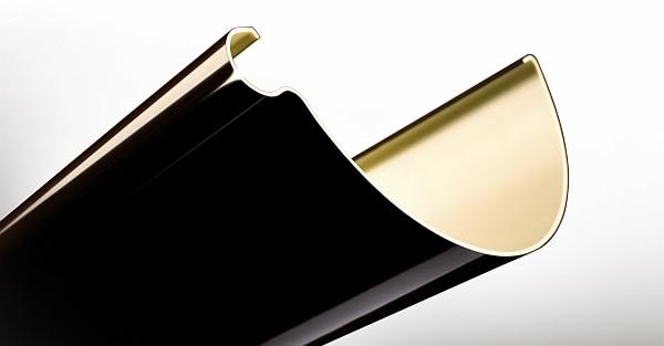 Błyszcząca, czarna rynna dachowa z wewnętrzną, złotą powłoką, sfotografowana z bliska na białym tle, ukazująca precyzję wykonania i nowoczesny design.