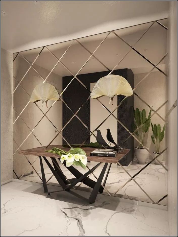 Ściana z lustrzanych rombów w przedpokoju, dekoracyjny stolik z kwiatami i figurkami ptaków, marmurowa podłoga.