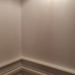 MB Constructions Michał Borkowski - Ściana w narożniku z kremową farbą, listwami przypodłogowymi i oświetleniem sufitowym