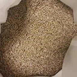 Wnętrze worka wypełnionego brązowym, drobnym granulatem opału z biomasy drzewnej.