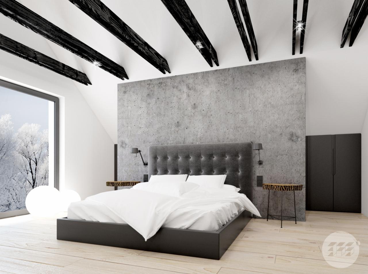Sypialnia na poddaszu z łóżkiem z szarym zagłówkiem na tle betonowej ściany, czarne belki stropowe i widok na zimowy krajobraz za oknem.