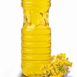 Butelka złocistego oleju rzepakowego z żółtymi kwiatami rzepaku u podstawy, na białym tle.