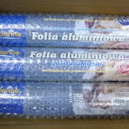 Trzy rolki folii aluminiowej gastronomicznej marki Clarina, zapakowane w folię bąbelkową, ułożone w kartonowym pudełku. Widoczne etykiety z napisem 'Folia aluminiowa gastronomiczna'.