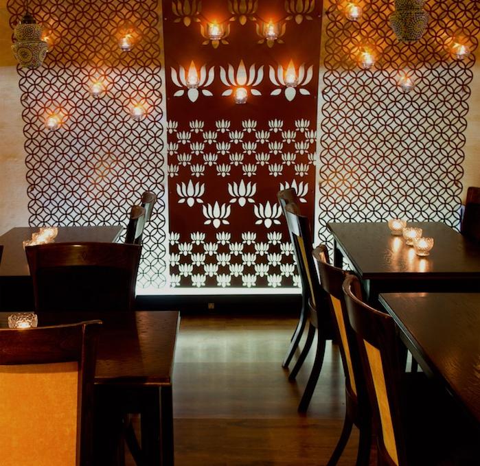 Elegancka aranżacja wnętrza biura w Krakowie z ciemnymi drewnianymi meblami, dekoracyjnymi ścianami z motywem kwiatowym i subtelnym oświetleniem.