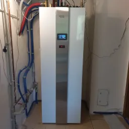 Nowoczesna jednostka centralna z wyświetlaczem, z licznymi rurami instalacyjnymi w tle, zainstalowana w pomieszczeniu w Łodzi.