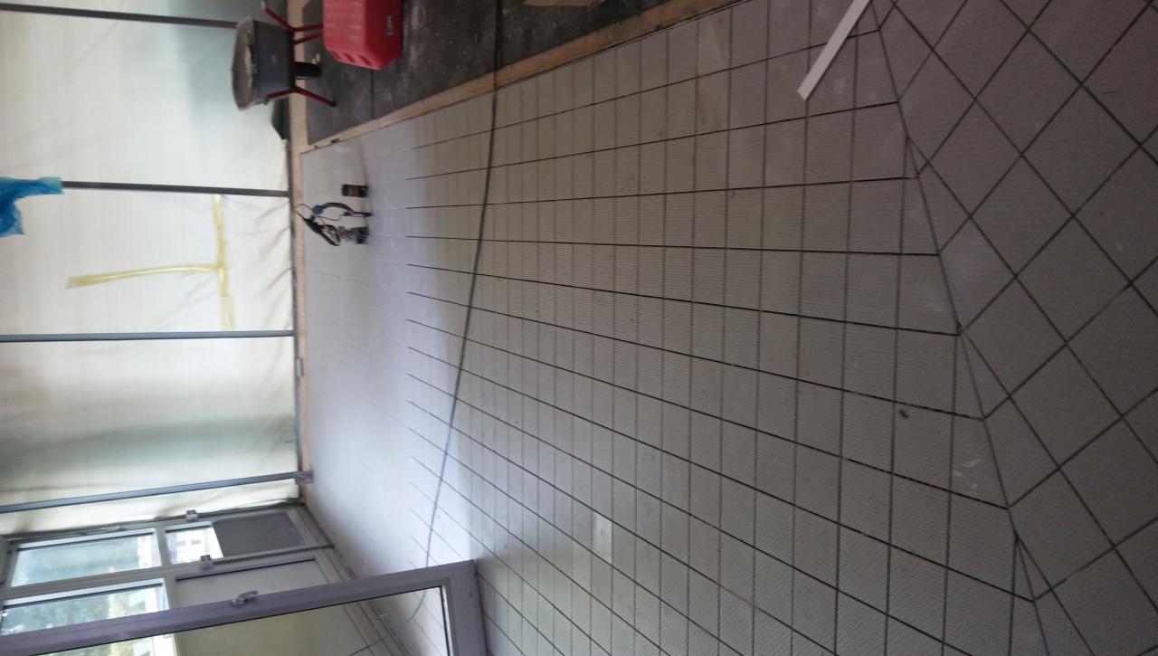 Przygotowana podłoga z siatką wzmacniającą przed wylaniem wylewki samopoziomującej, widoczne narzędzia i wiadro w tle.