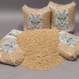 Pellet z motywem kota w przezroczystych workach 15kg, ułożony na szarym tle. Widoczne granulki rozsypane obok worków. Produkt gotowy do sprzedaży.