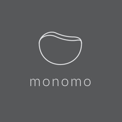 Minimalistyczne logo 'monomo' z abstrakcyjnym symbolem w kształcie zaokrąglonego kamienia na szarym tle.