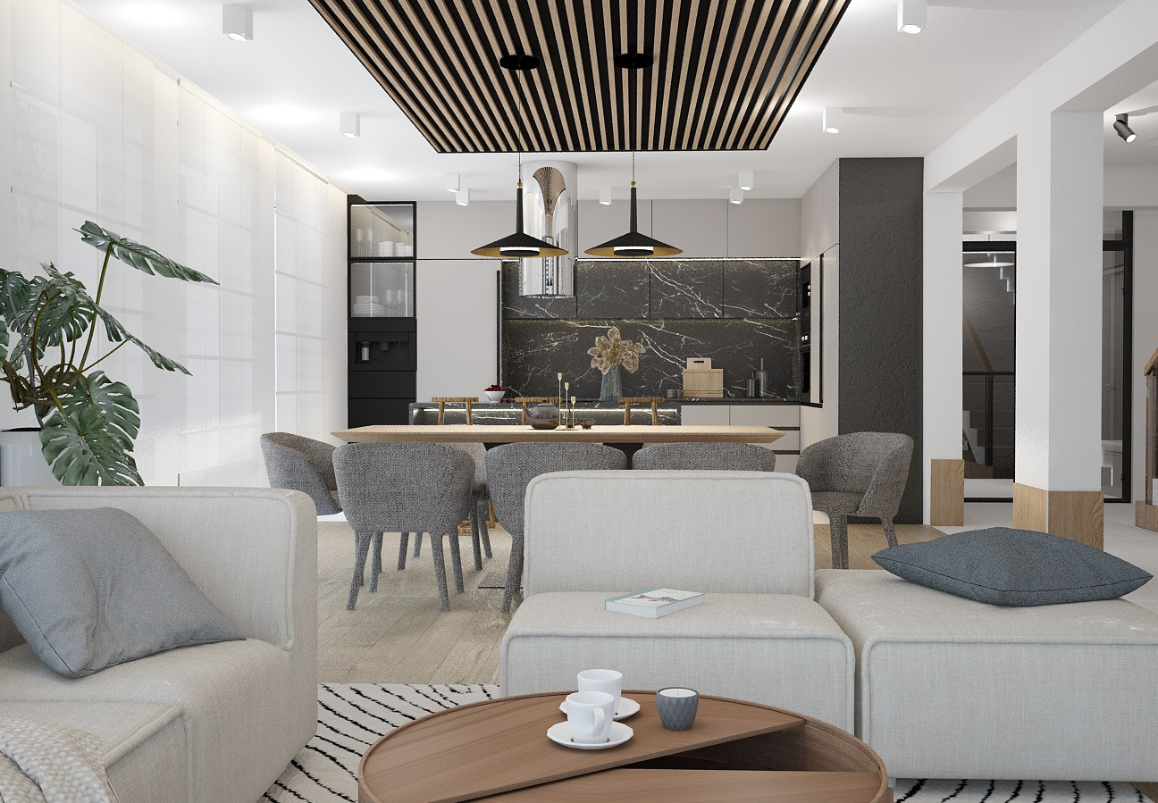 Jasne, przestronne wnętrze z otwartą kuchnią, jadalnią i salonem. Drewniany sufit lamelowy, marmurowy backsplash w kuchni, minimalistyczne meble i dekoracje. Na pierwszym planie stolik kawowy...