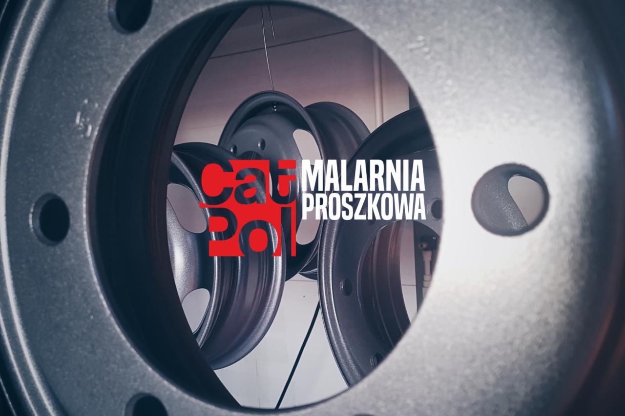 Felgi samochodowe po malowaniu proszkowym, widoczne logo 'Cat Pol Malarnia Proszkowa' w czerwono-białej kolorystyce, ujęcie przez otwór w innej feldze.