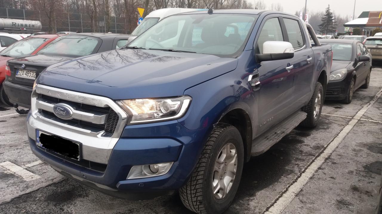 Niebieski Ford Ranger Limited zaparkowany na parkingu, widoczny z przodu, z włączonymi światłami dziennymi.